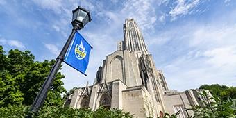 Cathedral of Learning with Pitt banner on lamp post in foreground