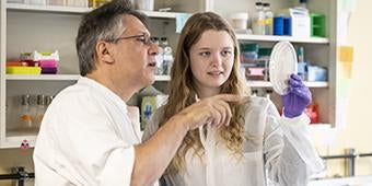 Graham Hatfull and student look at petri dish in lab
