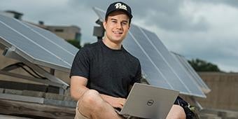 undergrad student performing research with solar panels