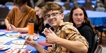 student gives thumbs up during a fun group painting activity